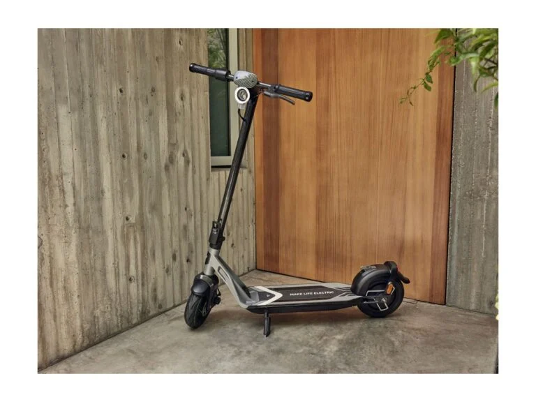 NIU KQi Air electric scooter by a front door