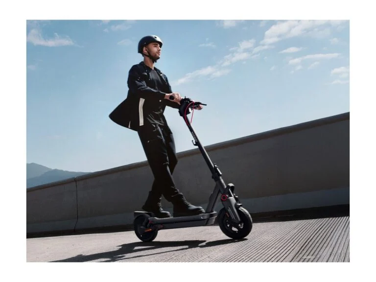 A man in a helmet on a Segway Ninebot MAX G3 E electric scooter